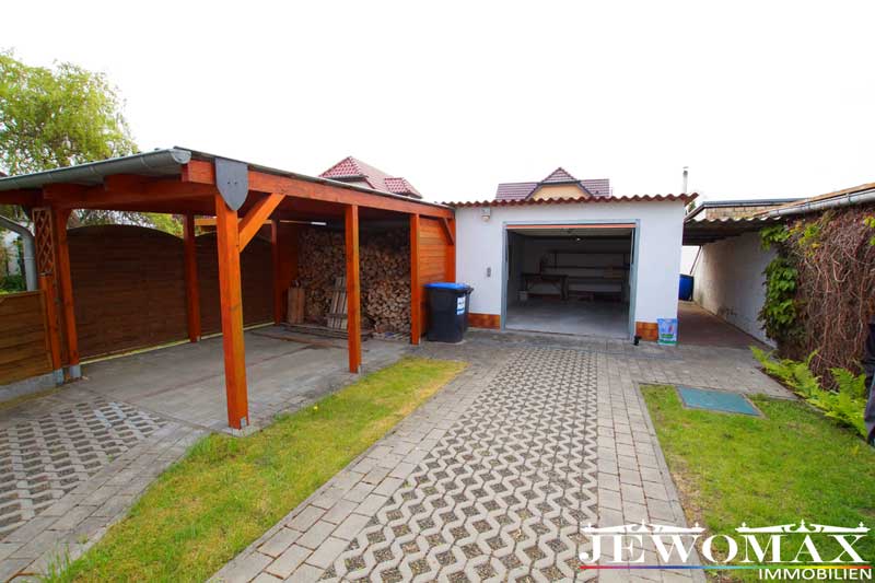 Carport mit Brennholz + Garage und Durchgang zum Haus
